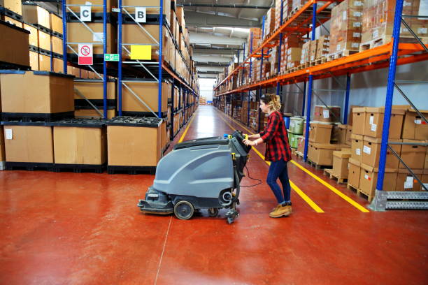 Industrial floor cleaner machine with squeegee blades in a warehouse.